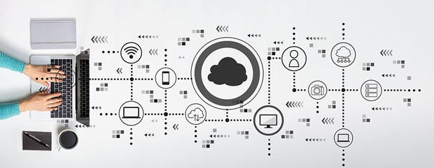 Stock image of a laptop seen from above with coffee and pen and paper on left and icons representing cloud services on the right